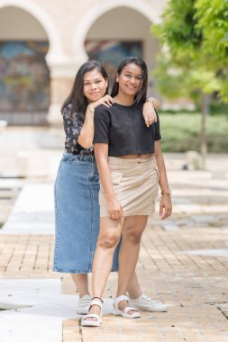 30 küsur Hintli kadın çeşitli şekillerde poz veriyor ve Malezya 'nın başkenti Kuala Lumpur' da tarihi bir parktaki güzel bir binanın önünde tatilin tadını çıkarıyorlar..