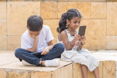 30 yaşlarında kot etekli Hintli bir anne ve beyaz tişörtlü 7 yaşındaki oğlu Malezya 'nın başkenti Kuala Lumpur' da tarihi bir parkta neşe içinde vakit geçiriyorlar..