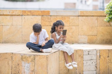 30 yaşlarında kot etekli Hintli bir anne ve beyaz tişörtlü 7 yaşındaki oğlu Malezya 'nın başkenti Kuala Lumpur' da tarihi bir parkta neşe içinde vakit geçiriyorlar..