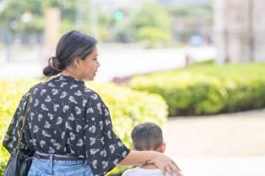 7 yaşındaki oğulları ve 5 yaşındaki kızlarıyla birlikte Kuala Lumpur, Malezya 'daki batı tarzı tarihi bir binanın önünde mutlu mesut yürüyen 30 küsur Hintli anne..