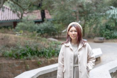 Hong Kong 'da Kowloon Park, Tsim Sha Tsui, Kowloon Adası, Hong Kong' da duran 30 yaşlarında kızıl saçlı bir kadın..