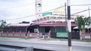 Selangor, Malezya 'da halka açık bir yolda, hareket halindeki bir arabanın içinden şehre yavaş çekim görüntüsü.
