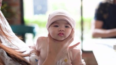 Malezya, Selangor 'da şık bir kafede aile tarafından geğirilen yeni doğan Malay bebeğinin yavaş çekim videosu..