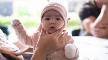 Malezya, Selangor 'da şık bir kafede aile tarafından geğirilen yeni doğan Malay bebeğinin yavaş çekim videosu..