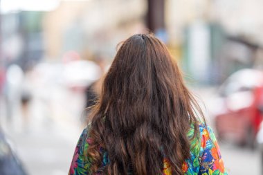 50 'li yaşlarda Malezyalı bir adam ve 30' lu yaşlarda renkli elbiseli bir Çinli kadın, Malezya, Kuala Lumpur 'da bir tren istasyonunda bavullarıyla birlikte yürüyorlar..