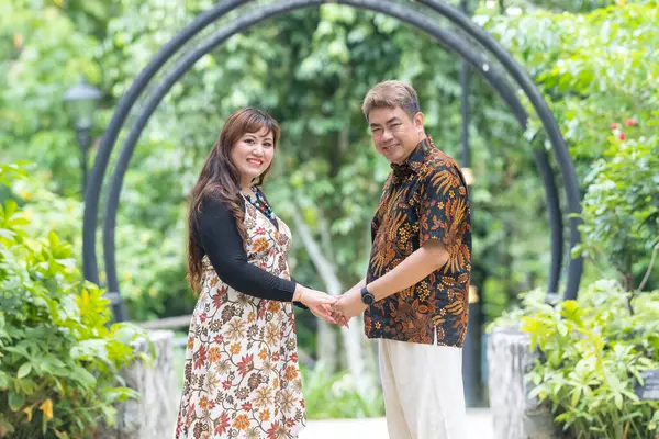 50 'li yaşlarında Malezyalı bir adam geleneksel 30' lu yaşlarda geleneksel bir elbise giyen Çinli bir kadın Malezya 'nın başkenti Kuala Lumpur' da Taman Botani Perdana 'da bir anma fotoğrafına poz veriyor..