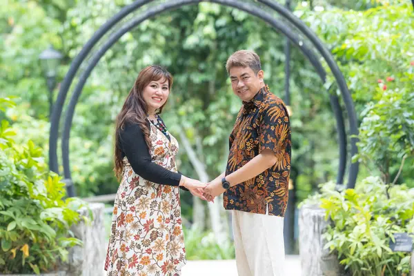 50 'li yaşlarında Malezyalı bir adam geleneksel 30' lu yaşlarda geleneksel bir elbise giyen Çinli bir kadın Malezya 'nın başkenti Kuala Lumpur' da Taman Botani Perdana 'da bir anma fotoğrafına poz veriyor..