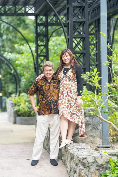 50 'li yaşlarında Malezyalı bir adam geleneksel 30' lu yaşlarda geleneksel bir elbise giyen Çinli bir kadın Malezya 'nın başkenti Kuala Lumpur' da Taman Botani Perdana 'da bir anma fotoğrafına poz veriyor..