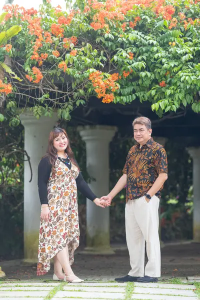 50 'li yaşlarında Malezyalı bir adam geleneksel 30' lu yaşlarda geleneksel bir elbise giyen Çinli bir kadın Malezya 'nın başkenti Kuala Lumpur' da Taman Botani Perdana 'da bir anma fotoğrafına poz veriyor..
