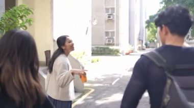 Tayvanlı erkek ve kadın 20 'li yaşlarda ve Güney Asyalı bir kadın birlikte yürüyorlar ve Tayvan, Daan Bölgesi' nde bir üniversite kampüsünde arkadaşça sohbet ediyorlar. Yavaş çekim