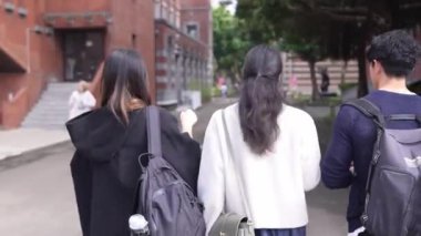 Tayvanlı erkek ve kadın 20 'li yaşlarda ve Güney Asyalı bir kadın birlikte yürüyorlar ve Tayvan, Daan Bölgesi' nde bir üniversite kampüsünde arkadaşça sohbet ediyorlar. Yavaş çekim