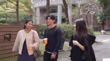 Tayvanlı erkek ve kadın 20 'li yaşlarda ve Güney Asyalı bir kadın birlikte yürüyorlar ve Tayvan, Daan Bölgesi' nde bir üniversite kampüsünde arkadaşça sohbet ediyorlar. Yavaş çekim