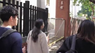 Tayvanlı erkek ve kadın 20 'li yaşlarda ve Güney Asyalı bir kadın birlikte yürüyorlar ve Tayvan, Daan Bölgesi' nde bir üniversite kampüsünde arkadaşça sohbet ediyorlar. Yavaş çekim