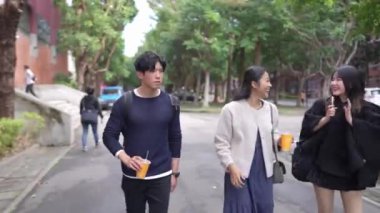 Tayvanlı erkek ve kadın 20 'li yaşlarda ve Güney Asyalı bir kadın birlikte yürüyorlar ve Tayvan, Daan Bölgesi' nde bir üniversite kampüsünde arkadaşça sohbet ediyorlar. Yavaş çekim