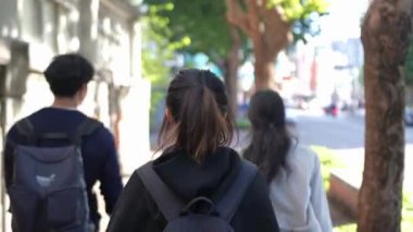 Tayvanlı erkek ve kadın 20 'li yaşlarda ve Güney Asyalı bir kadın birlikte yürüyorlar ve Tayvan' ın Taipei şehrindeki Daan Bölgesi 'nde bir üniversite yakınlarında arkadaşça sohbet ediyorlar. Yavaş çekim