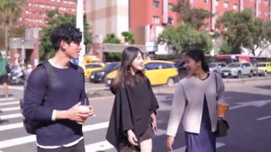 Tayvanlı erkek ve kadın 20 'li yaşlarda ve Güney Asyalı bir kadın birlikte yürüyorlar ve Tayvan' ın Taipei şehrindeki Daan Bölgesi 'nde bir üniversite yakınlarında arkadaşça sohbet ediyorlar. Yavaş çekim