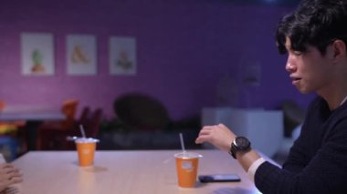 Tayvanlı erkek ve kadın 20 'li yaşlarda ve Güney Asyalı bir kadın Daan Bölgesi, Tayvan' da bir üniversite kafeteryasında arkadaşça sohbet ediyorlar. Yavaş çekim