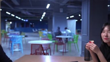 Tayvanlı erkek ve kadın 20 'li yaşlarda ve Güney Asyalı bir kadın Daan Bölgesi, Tayvan' da bir üniversite kafeteryasında arkadaşça sohbet ediyorlar. Yavaş çekim