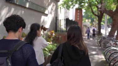 Da 'an Bölgesi' nde, Taipei 'de, bir üniversitenin yakınındaki bir sokakta yürüyen ve sohbet eden yirmili yaşlardaki iki kadını, bir Tayvanlı ve diğer Güney Asyalıyı gösteren yavaş çekim bir video var..