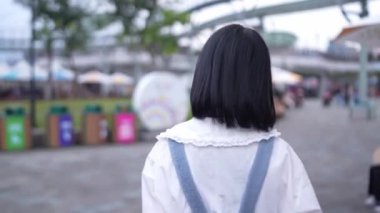 Tayvan 'ın Shilin Bölgesi' nde, Tayvanlı bir kadın, 20 'li yaşlarda, Tayvan' daki eğlence parkında geziniyor ve keşfe çıkıyor..