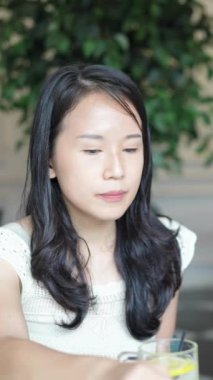 Haziran 'da Selangor Malezya' da yirmili yaşlarda Çinli bir kadın ağır çekimde çekilen dikey videoda Batı tarzı bir kafede pasta yiyor.