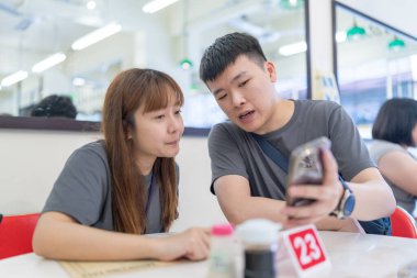 30 'lu yaşlarda Çinli bir çift Malezya' nın başkenti Kuala Lumpur 'da ünlü bir Çin restoranında sohbet ediyorlar..