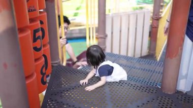 Malezyalı 30 'lu ve 1 yaşındaki Çinli ebeveynler, Malezya' nın başkenti Kuala Lumpur 'da Haziran sabahı KLCC Parkı' nda salıncak ve tahterevallilerle mutlu bir şekilde oynuyorlar..