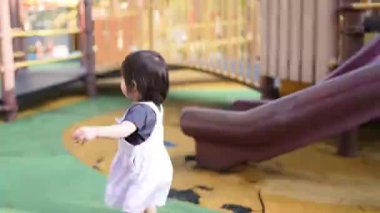 Malezyalı 30 'lu ve 1 yaşındaki Çinli ebeveynler, Malezya' nın başkenti Kuala Lumpur 'da Haziran sabahı KLCC Parkı' nda salıncak ve tahterevallilerle mutlu bir şekilde oynuyorlar..