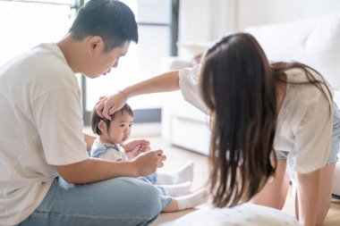 Tayvanlı bir kız, Tayvan 'ın başkenti Tayvan' da yüksek bir apartman dairesinde 20 'li yaşlarında bir erkek ve kadın olan ailesiyle mutlu bir şekilde vakit geçiriyor..