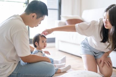 Tayvanlı bir kız, Tayvan 'ın başkenti Tayvan' da yüksek bir apartman dairesinde 20 'li yaşlarında bir erkek ve kadın olan ailesiyle mutlu bir şekilde vakit geçiriyor..