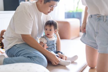 Tayvanlı bir kız, Tayvan 'ın başkenti Tayvan' da yüksek bir apartman dairesinde 20 'li yaşlarında bir erkek ve kadın olan ailesiyle mutlu bir şekilde vakit geçiriyor..