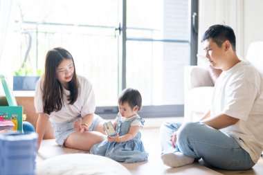 Tayvanlı bir kız, Tayvan 'ın başkenti Tayvan' da yüksek bir apartman dairesinde 20 'li yaşlarında bir erkek ve kadın olan ailesiyle mutlu bir şekilde vakit geçiriyor..