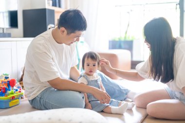 Tayvanlı bir kız, Tayvan 'ın başkenti Tayvan' da yüksek bir apartman dairesinde 20 'li yaşlarında bir erkek ve kadın olan ailesiyle mutlu bir şekilde vakit geçiriyor..