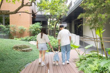 Tayvanlı bir kız, Eylül 'de Tayvan' ın Tayvan şehrinin sokaklarında güneşli bir günde, 20 'li yaşlarda bir erkek ve kadın, ailesiyle el ele yürüyor..