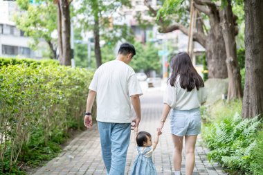 Tayvanlı bir kız, Eylül 'de Tayvan' ın Tayvan şehrinin sokaklarında güneşli bir günde, 20 'li yaşlarda bir erkek ve kadın, ailesiyle el ele yürüyor..
