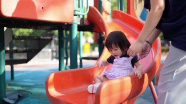 Malezyalı 30 'lu ve 1 yaşındaki Çinli ebeveynler, Malezya' nın başkenti Kuala Lumpur 'da Haziran sabahı KLCC Parkı' nda salıncak ve tahterevallilerle mutlu bir şekilde oynuyorlar..