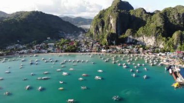 İnsansız hava aracı görüntüleri Mayıs ayında Filipinler 'in Palawan Adası' ndaki gizli bir cennet olan El Nido 'da şehir alanını, adaları, dağları, plajları ve ferahlatıcı güneş ışığındaki tekneleri gösteriyor..