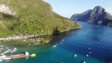 İnsansız hava aracı görüntüleri Mayıs ayında Filipinler 'in Palawan Adası' ndaki gizli bir cennet olan El Nido 'da şehir alanını, adaları, dağları, plajları ve ferahlatıcı güneş ışığındaki tekneleri gösteriyor..