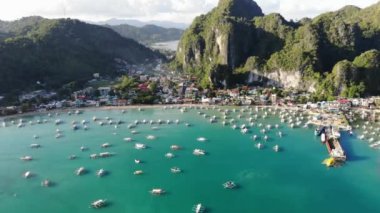 İnsansız hava aracı görüntüleri Mayıs ayında Filipinler 'in Palawan Adası' ndaki gizli bir cennet olan El Nido 'da şehir alanını, adaları, dağları, plajları ve ferahlatıcı güneş ışığındaki tekneleri gösteriyor..