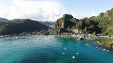 İnsansız hava aracı görüntüleri Mayıs ayında Filipinler 'in Palawan Adası' ndaki gizli bir cennet olan El Nido 'da şehir alanını, adaları, dağları, plajları ve ferahlatıcı güneş ışığındaki tekneleri gösteriyor..