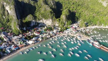 İnsansız hava aracı görüntüleri Mayıs ayında Filipinler 'in Palawan Adası' ndaki gizli bir cennet olan El Nido 'da şehir alanını, adaları, dağları, plajları ve ferahlatıcı güneş ışığındaki tekneleri gösteriyor..