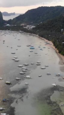 Mayıs 'ta gün batımında çekilen dikey İHA görüntüleri Filipinler' in Palawan Adası 'ndaki gizli bir cennet ve turizm merkezi olan El Nido' da gizli bir plajı, adaları, dağları, plajları ve tekneleri gösteriyor..