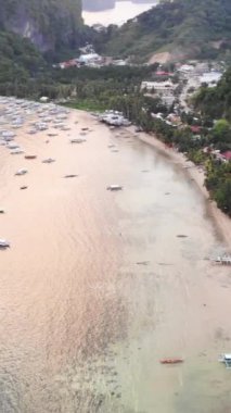 Mayıs 'ta gün batımında çekilen dikey İHA görüntüleri Filipinler' in Palawan Adası 'ndaki gizli bir cennet ve turizm merkezi olan El Nido' da gizli bir plajı, adaları, dağları, plajları ve tekneleri gösteriyor..