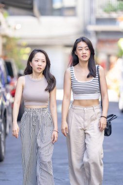 Eylül 'de Tayvan' ın Taipei şehrinde Dihua Caddesi 'nde 30' lu yaşlarda sıradan kıyafetler giyen iki Tayvanlı kadın yürüyor..