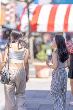 Eylül 'de Tayvan' ın Taipei şehrinde Dihua Caddesi 'nde 30' lu yaşlarda sıradan kıyafetler giyen iki Tayvanlı kadın yürüyor..