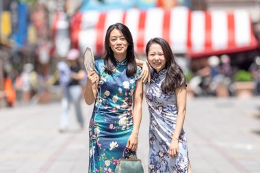 30 'lu yaşlarda, geleneksel Çin kıyafetleri giyen iki Tayvanlı kadın Eylül ayında Tayvan' ın Taipei şehrindeki Dihua Caddesi 'nde eğleniyorlar..