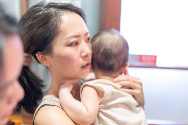 30 'lu yaşlarda iki Tayvanlı kadın 6 aylık bir bebek taşıyor ve Eylül ayında Tayvan' ın Taipei şehrindeki Dihua Caddesi 'nde hazırlanıyorlar..