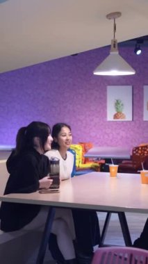Tayvanlı 20 'li yaşlarda genç bir erkek ve kadın üniversite öğrencisi, Hintli bir kadınla birlikte Taipei City Dikey Bölgesi Da' an Üniversitesi 'nin kafeteryasında sohbet ediyorlar.