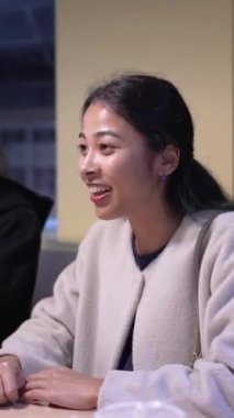 Tayvanlı 20 'li yaşlarda genç bir erkek ve kadın üniversite öğrencisi, Hintli bir kadınla birlikte Taipei City Dikey Bölgesi Da' an Üniversitesi 'nin kafeteryasında sohbet ediyorlar.