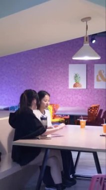 Tayvanlı 20 'li yaşlarda genç bir erkek ve kadın üniversite öğrencisi, Hintli bir kadınla birlikte Taipei City Dikey Bölgesi Da' an Üniversitesi 'nin kafeteryasında sohbet ediyorlar.